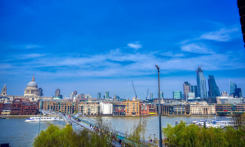 View of buildings at waterfront against cloudy sky