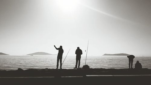 People on beach against clear sky