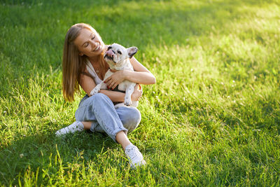 Full length of woman with dog on field