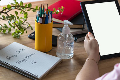 Midsection of woman using mobile phone on table