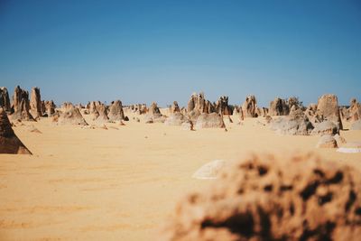 Panoramic view of desert against clear blue sky