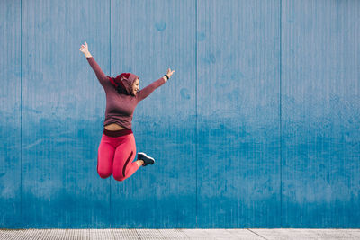 Full length of woman jumping in swimming pool