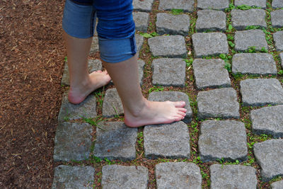 Low section of boy standing on footpath