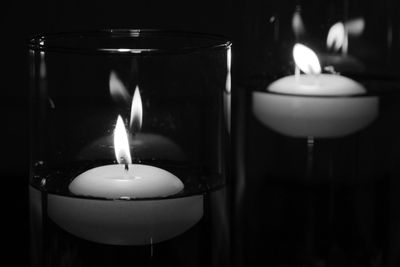 Close-up of illuminated tea light candle against black background