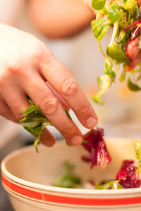 Close-up of hand holding salad in bowl