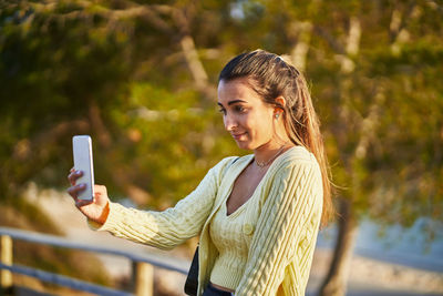 Young woman using mobile phone outdoors