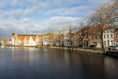 Arch bridge over river against buildings in city