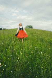 Rear view of woman sitting on field