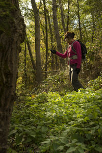 Woman walking with global positioning system in forest