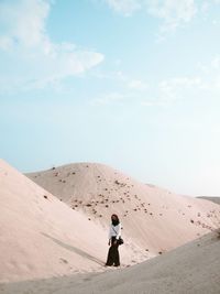 Rear view of woman standing in desert