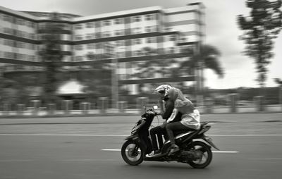 Side view of man riding motorcycle on road