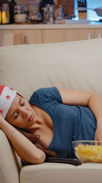 Woman lying on sofa at home