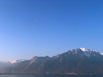 Scenic view of snowcapped mountains against clear blue sky