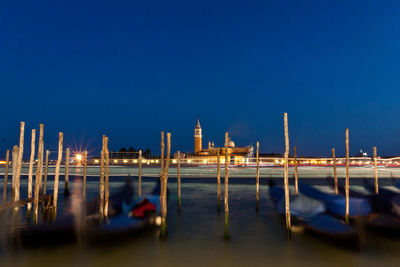 Gondolas moored on grand canal against st marks square at night