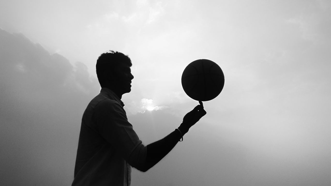 SIDE VIEW OF MAN WITH BALLOON AGAINST SKY