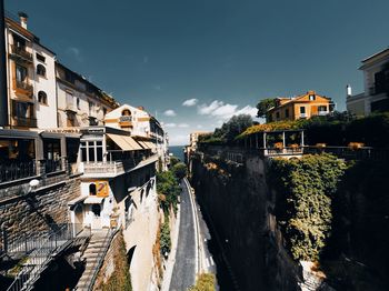 Canal amidst buildings in city against sky