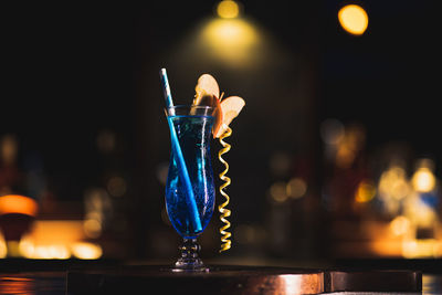 Close-up of illuminated candles on glass table