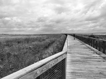 Pier on sea against cloudy sky