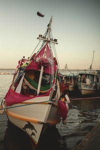 Fishing boat moored at beach against clear sky