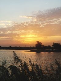 Scenic view of lake against romantic sky at sunset