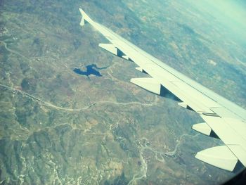 Aerial view of airplane wing over landscape