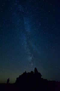 Low angle view of silhouette mountain against sky at night