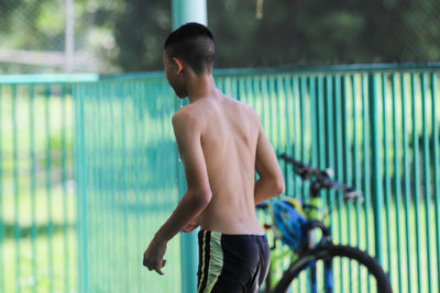 Full length of shirtless man standing in swimming pool 