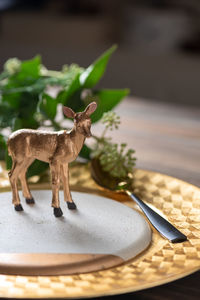 Close-up of deer figurine in plate on table