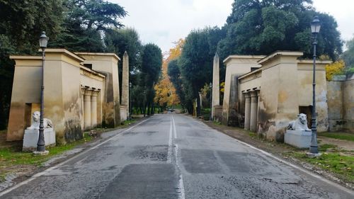 Road amidst trees against sky