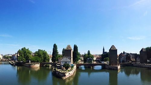 Bridge over river against sky in city