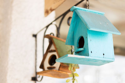 Close-up of birdhouse on clothesline against building