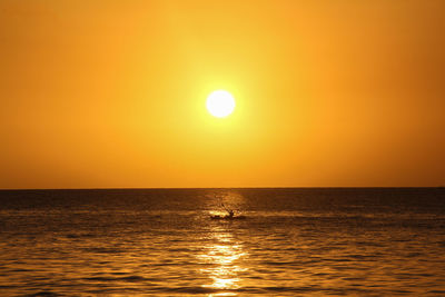 Scenic view of sea against orange sky