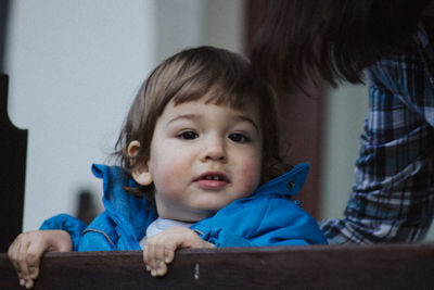 Close-up portrait of baby boy by railing