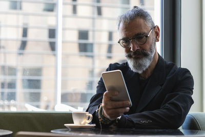 Man using phone while sitting on table