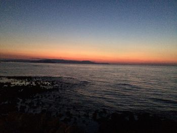 Scenic view of sea against clear sky at sunset