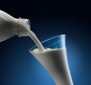 Close-up of ice cream in glass bottle against black background