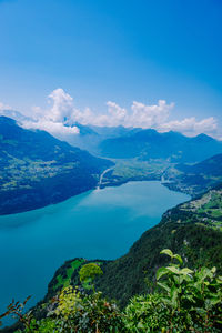 Scenic view of sea and mountains against blue sky