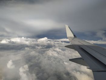 Airplane flying over cloudscape against sky