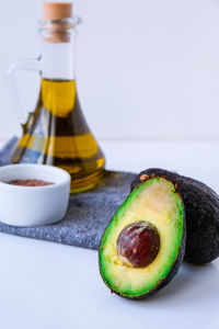 Olive oil in glass bottle with sesame and flax seeds. fresh ripe hass avocado. healthy eating. vegan