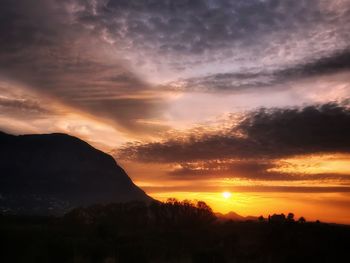 Scenic view of silhouette mountains against orange sky