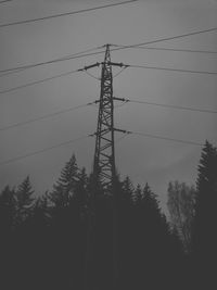 Low angle view of silhouette electricity pylon against sky