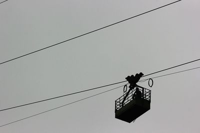 Low angle view of overhead cable car against sky