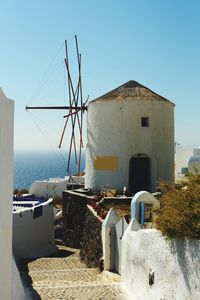 View of building by sea against clear blue sky