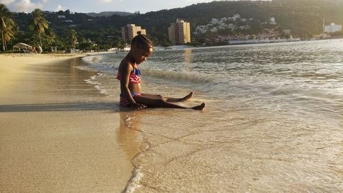 Young woman on shore against sky