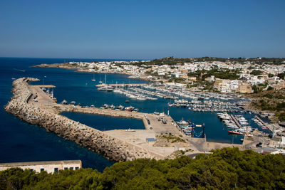 High angle view of townscape by sea against clear sky