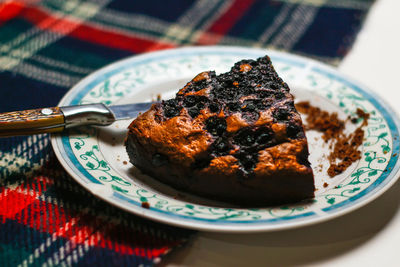 Close up piece of chocolate cake on a white plate with blue ornate patterns. brownie. cake.