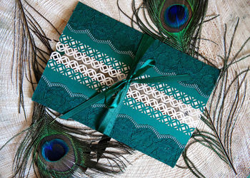 Close-up of peacock feathers with greeting card on table