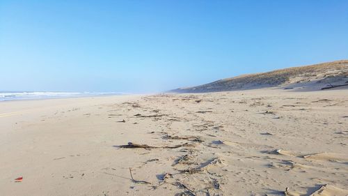 Scenic view of beach against clear blue sky