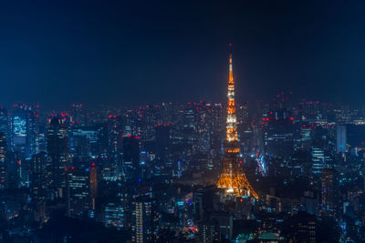 Tokyo tower against tokyo skyline at night, illuminated cityscape