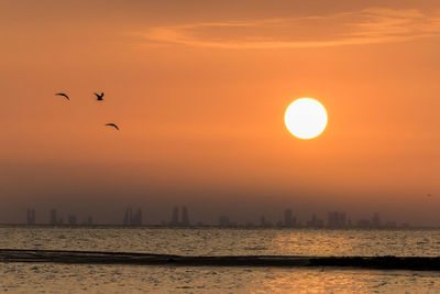 Scenic view of sea against orange sky